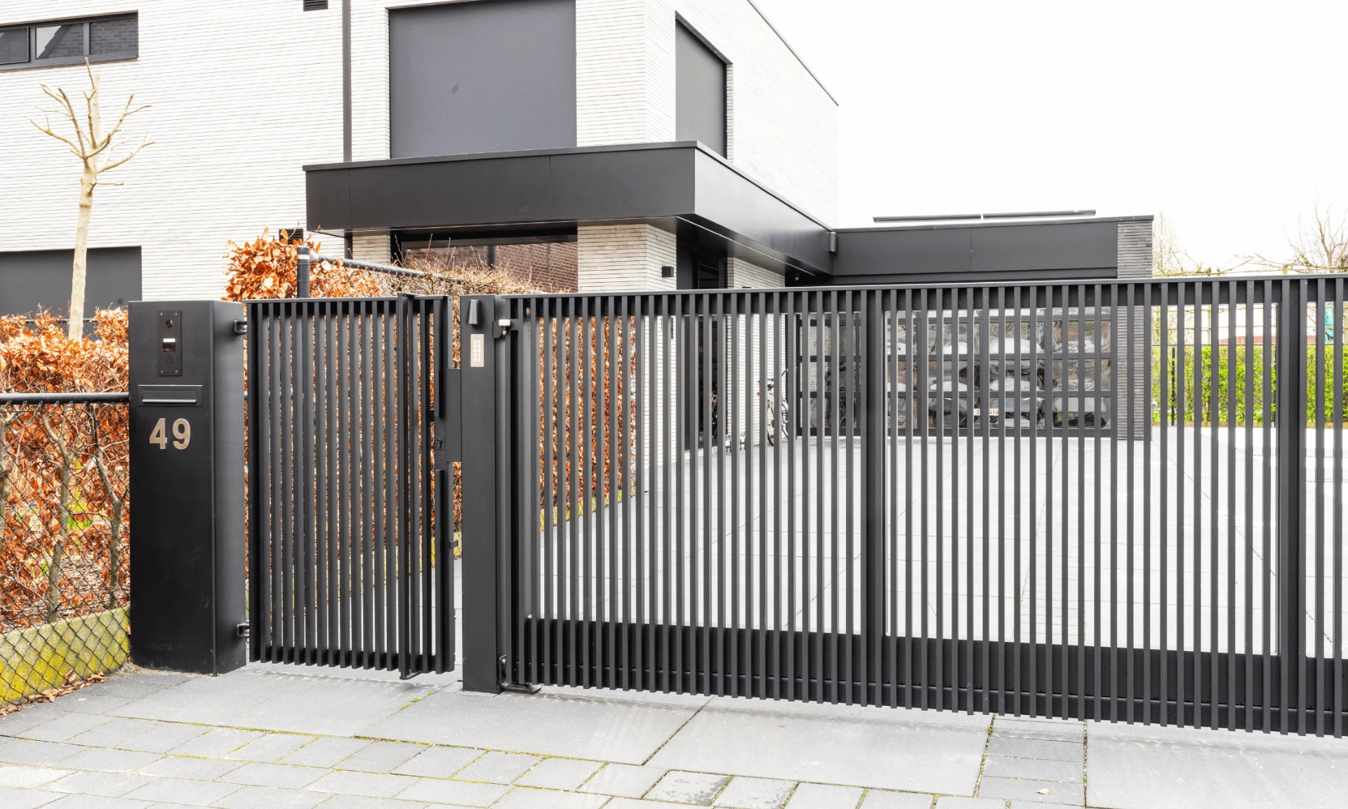 Zwarte schuifpoort en hekwerk op maat voor een moderne woning
