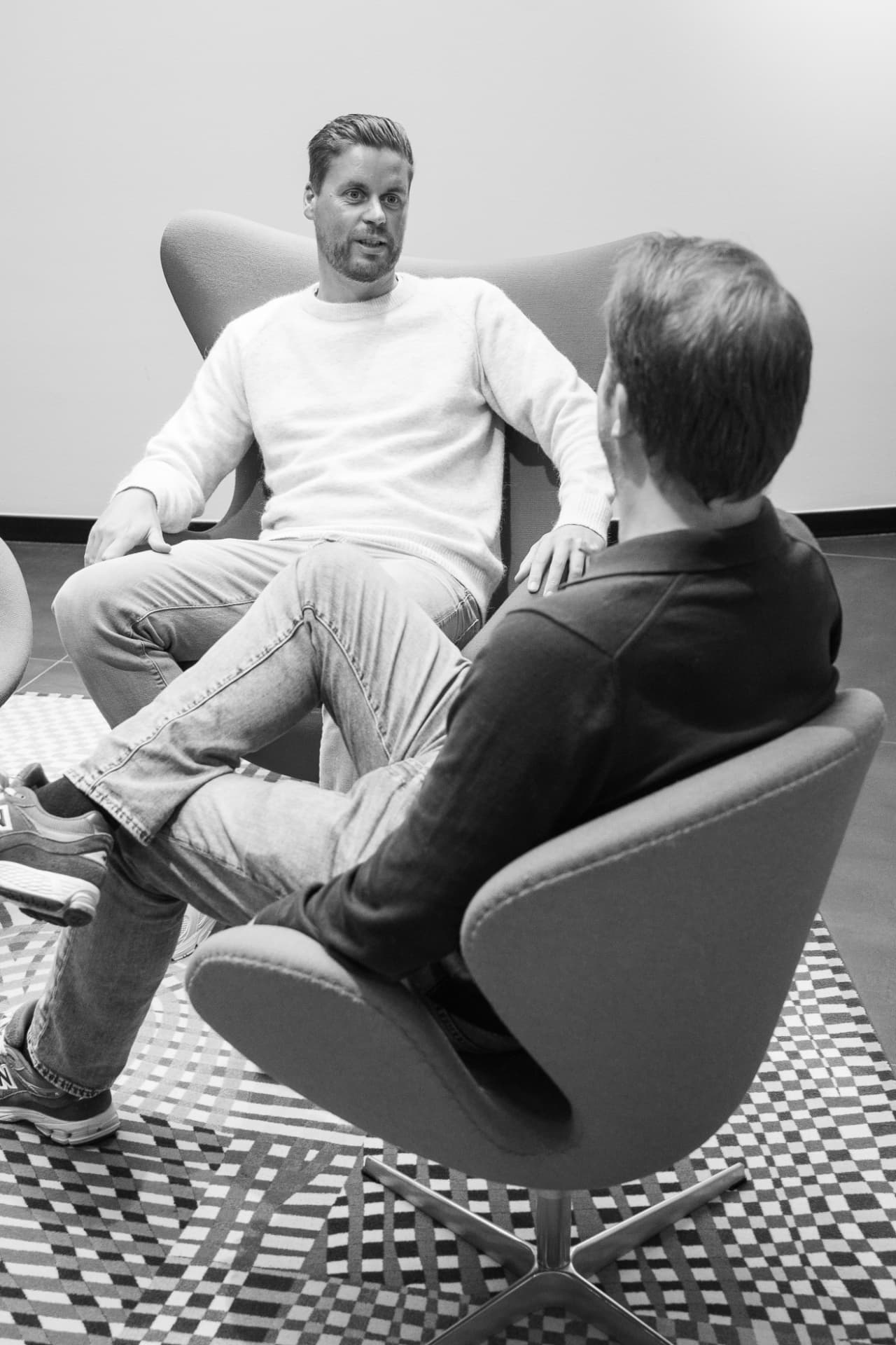 Twee collega's in gesprek in een moderne kantooromgeving