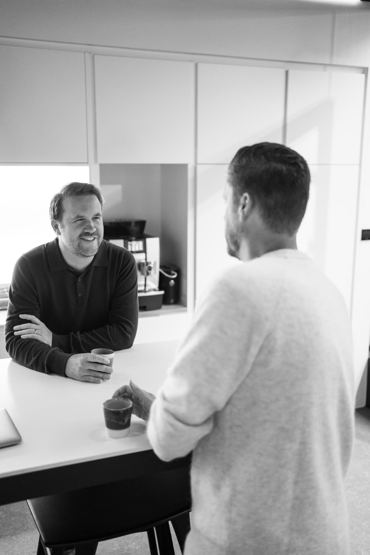 Twee Mavins-collega's in gesprek aan de koffiemachine